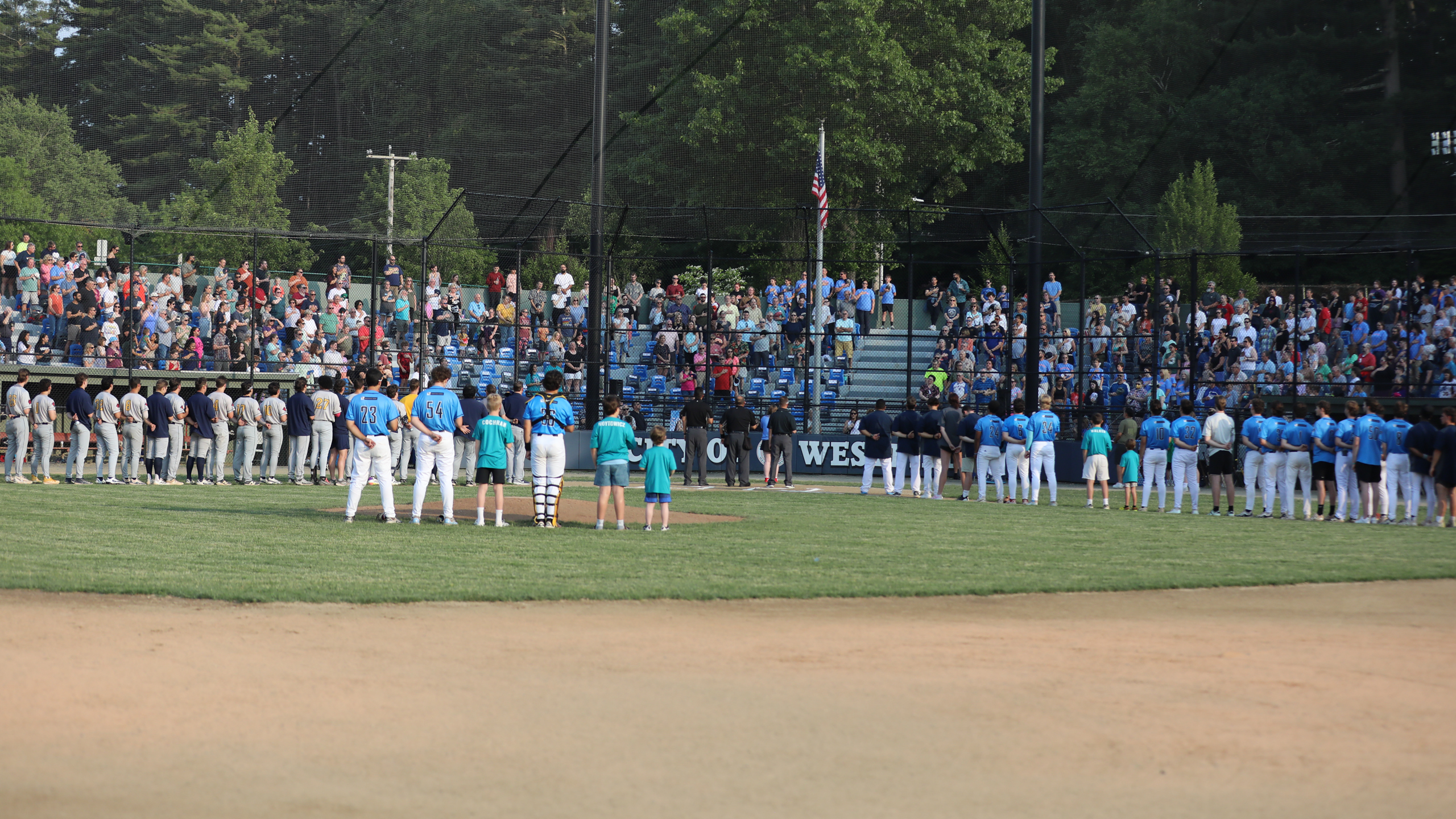 Players and fans stand during the national anthem on June 13, 2025