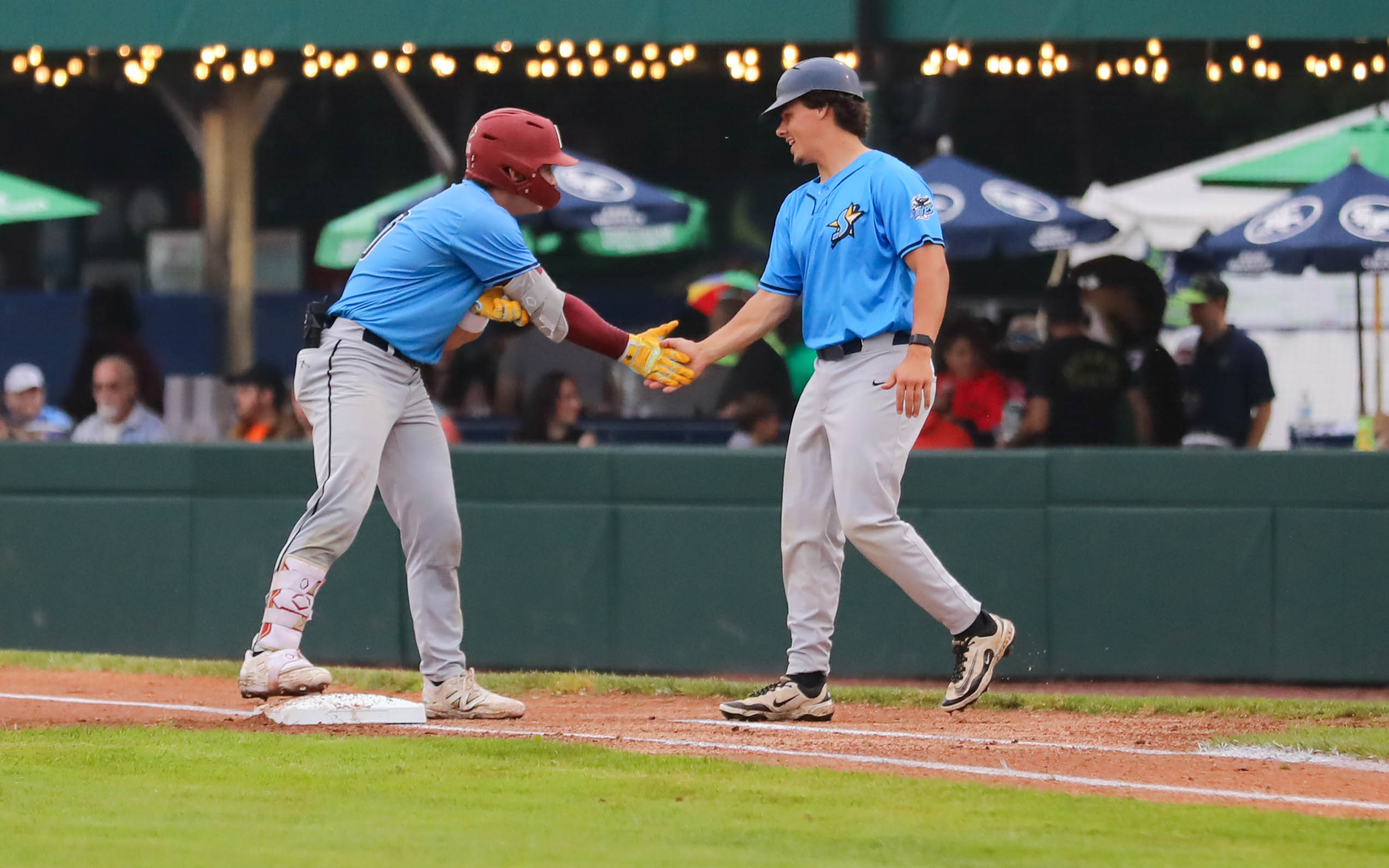 Two Starfires players high five at first base