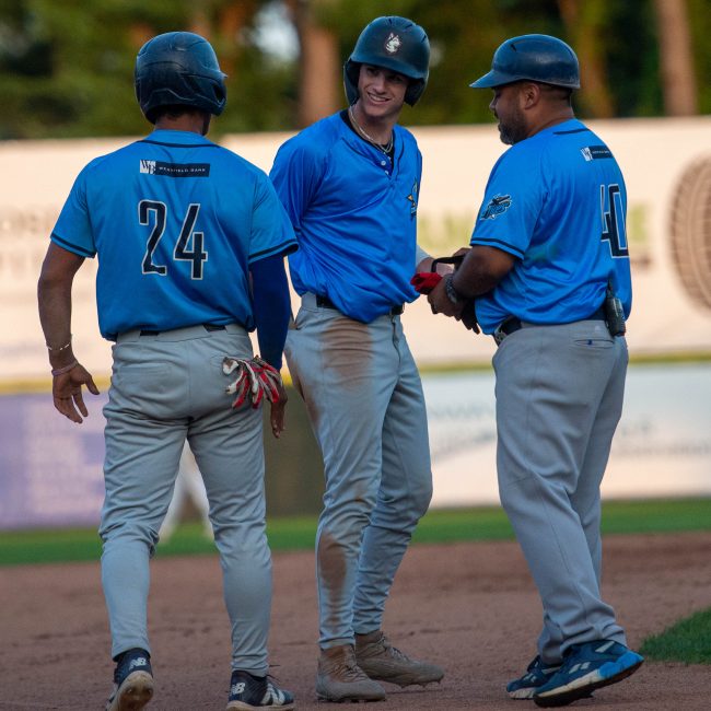 Ruggiero celebrates with Frometa and Bonfiglio at third base.