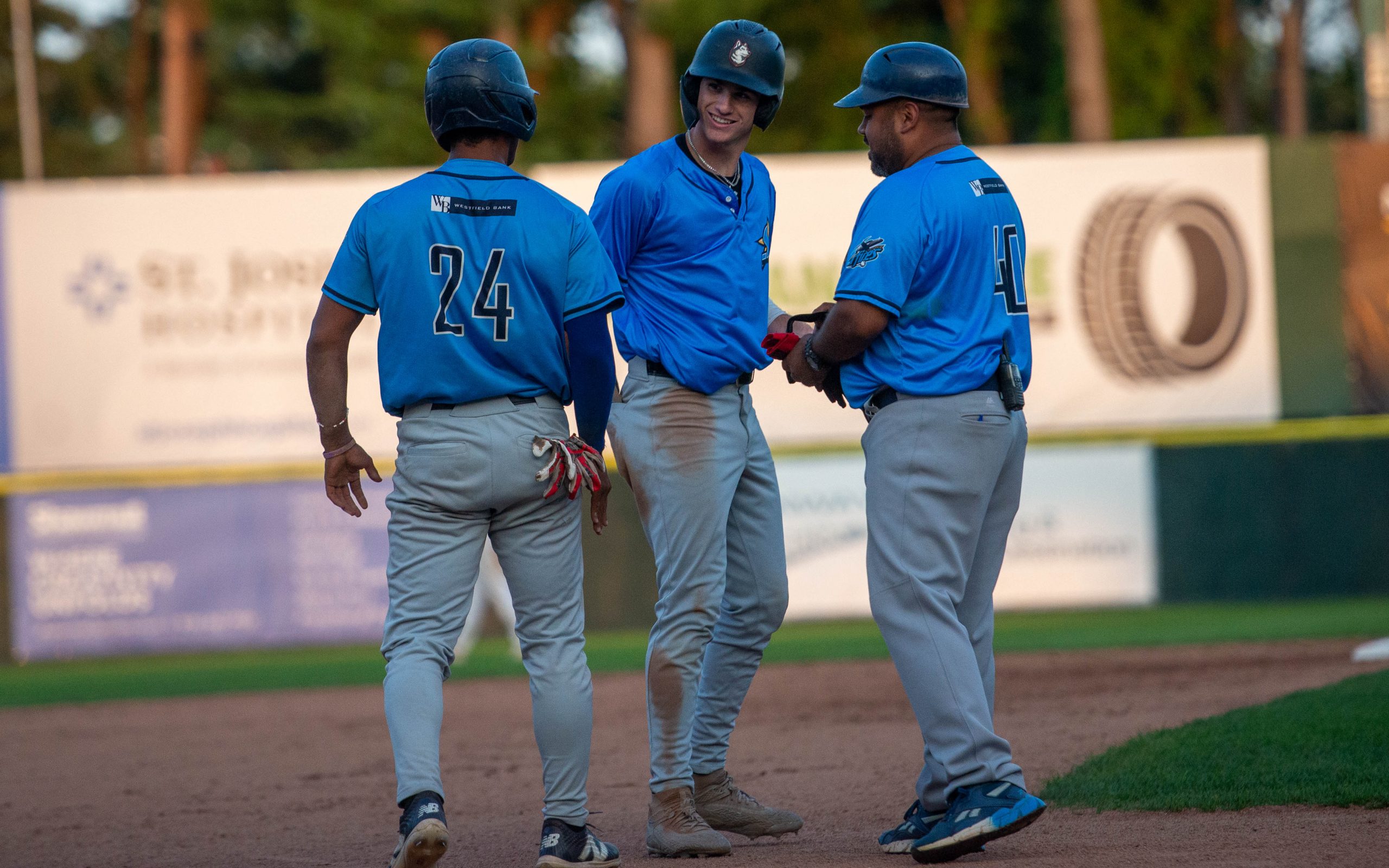 Ruggiero celebrates with Frometa and Bonfiglio at third base.
