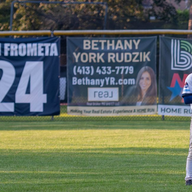 Josh Frometa during the National Anthem with his retired number banner in the background.