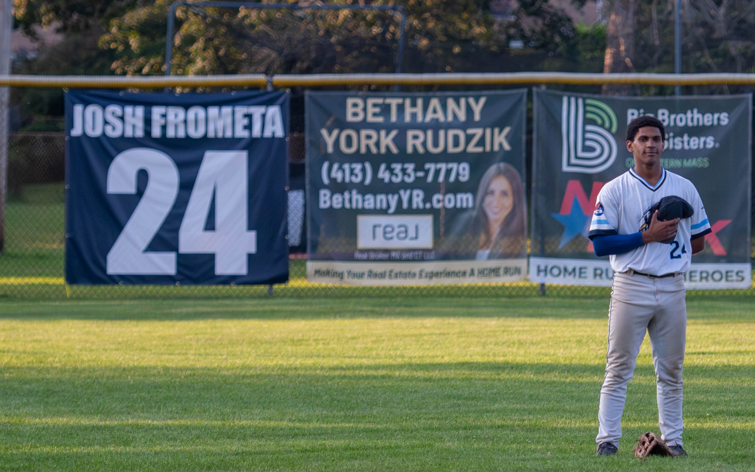 Josh Frometa during the National Anthem with his retired number banner in the background.