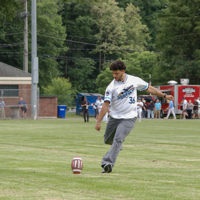 Andres Borregales kicks footballs to fans
