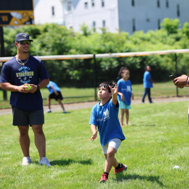 A student at Square One plays catch with Mike Cervoni and Josh Frometa