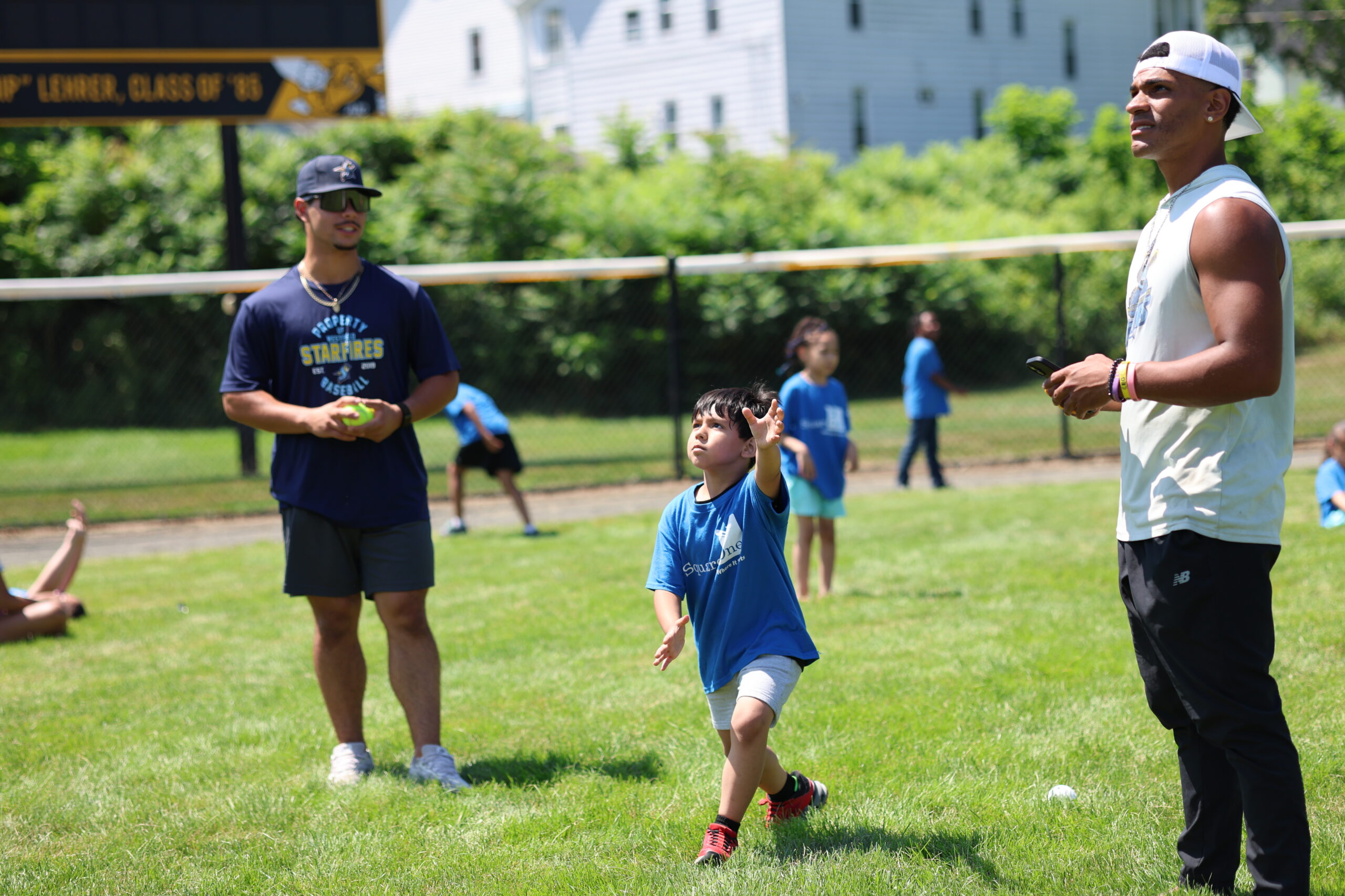 A student at Square One plays catch with Mike Cervoni and Josh Frometa